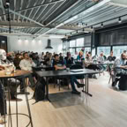 A lively business workshop engaging a diverse audience in a modern conference room.